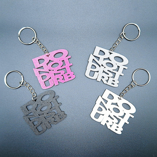 Four Do Not Disturb keychains shown in different colors, bold text design, perfect for privacy, work-from-home setups, or gamer accessories.