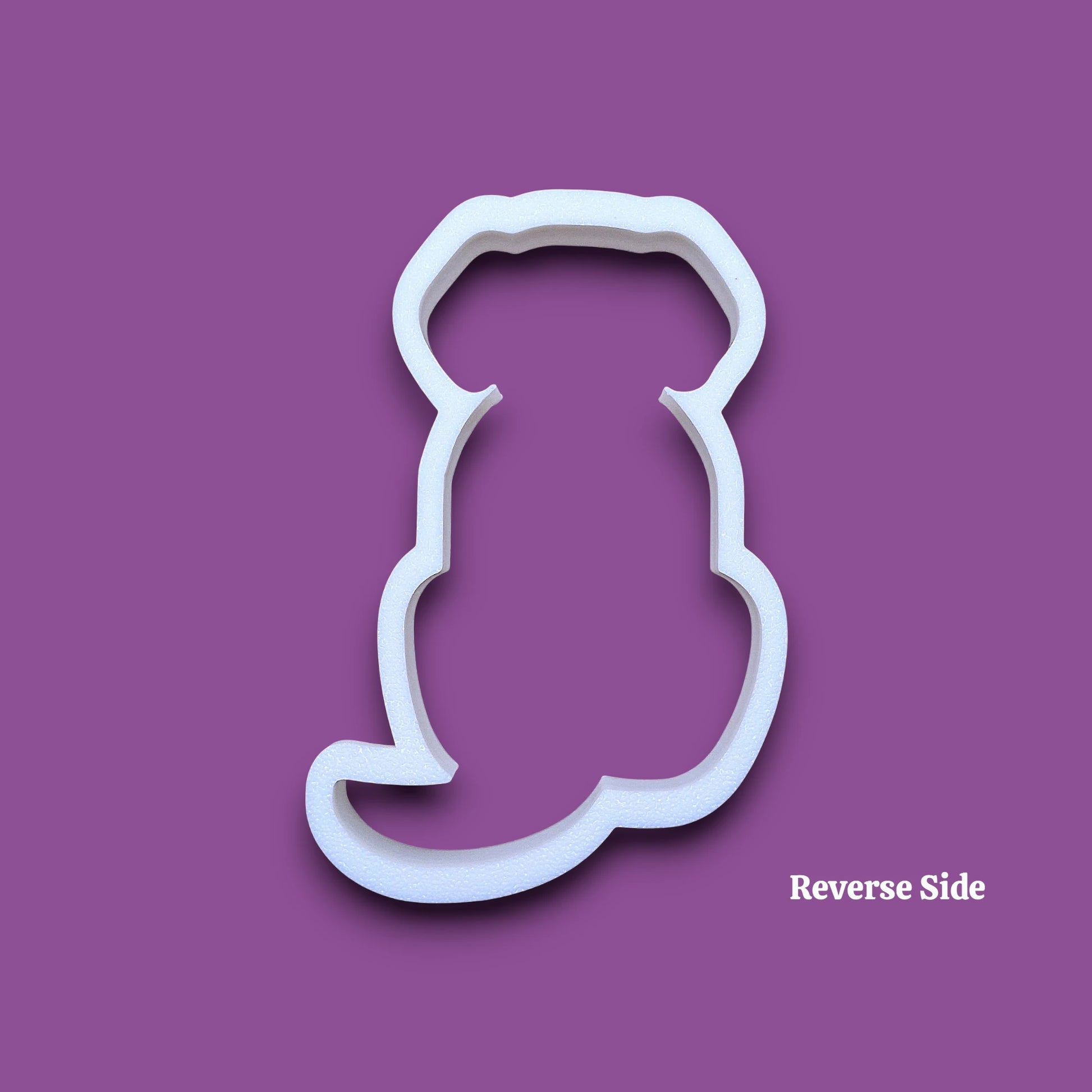 A white dog cookie cutter shown on a plain gray background with the word 'Reverse' in the bottom right corner.
