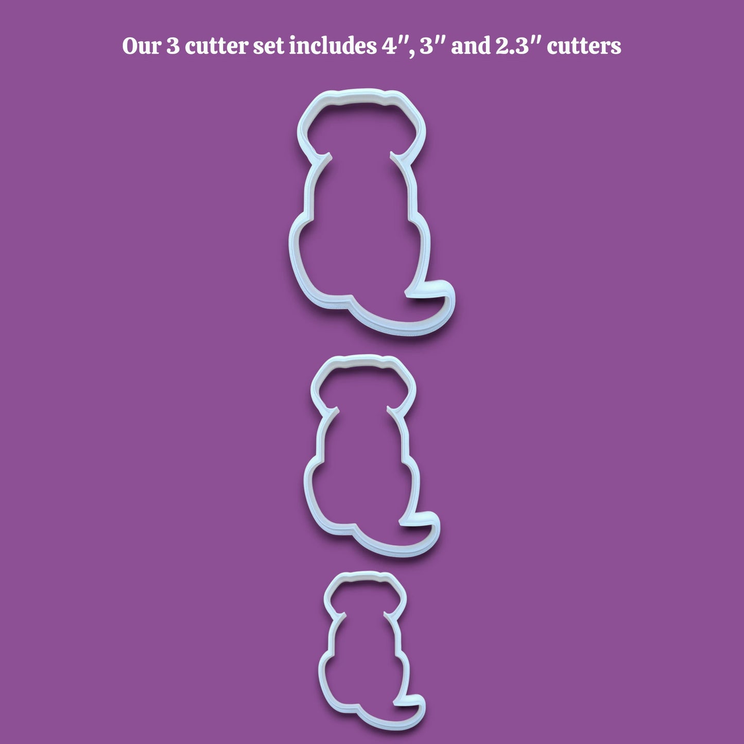 Three dog-shaped cookie cutters in sizes 4 inches, 3 inches, and 2.3 inches, shown vertically on a solid gray background with black text at the top reading 'Our 3 cutter set includes 4", 3" and 2.3" cutters'