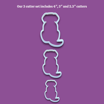 Three dog-shaped cookie cutters in sizes 4 inches, 3 inches, and 2.3 inches, shown vertically on a solid gray background with black text at the top reading 'Our 3 cutter set includes 4", 3" and 2.3" cutters'
