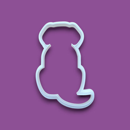 A plastic dog-shaped cookie cutter, shown on a solid background.