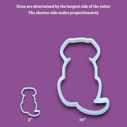 Two white dog cookie cutters in different sizes shown on a gray background with text explaining that sizes are determined by the longest side and the shorter side scales proportionately. The larger cutter is labeled 10 inches and the smaller cutter is labeled 2 inches.