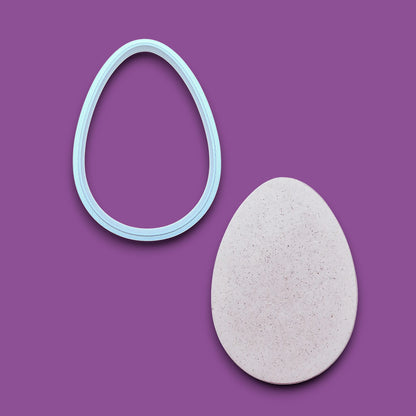Egg Cookie Cutter  alongside a dough cutout – Oval-shaped baking tool for cookies, fondant, sandwiches, and crafts, available in multiple sizes and vibrant colors.