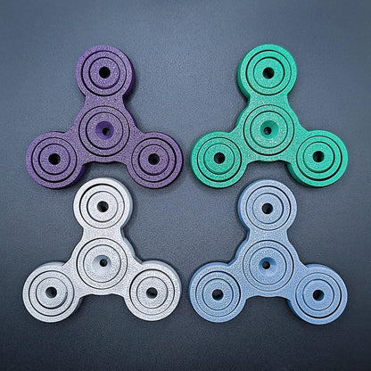 Colorful 3" pronged fidget gyro spinners in four colors—perfect stress relief tool for focus, anxiety, and sensory play. Eco-friendly, handmade.