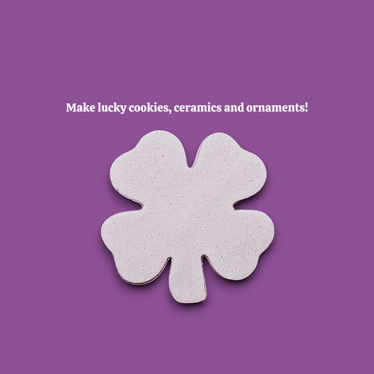 A single four-leaf clover-shaped dough cutout make from a shamrock cookie cutter.