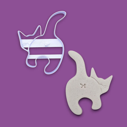 Cat butt cookie cutter alongside a dough cutout and imprint, perfect for gag gifts, funny treats and white elephant parties.