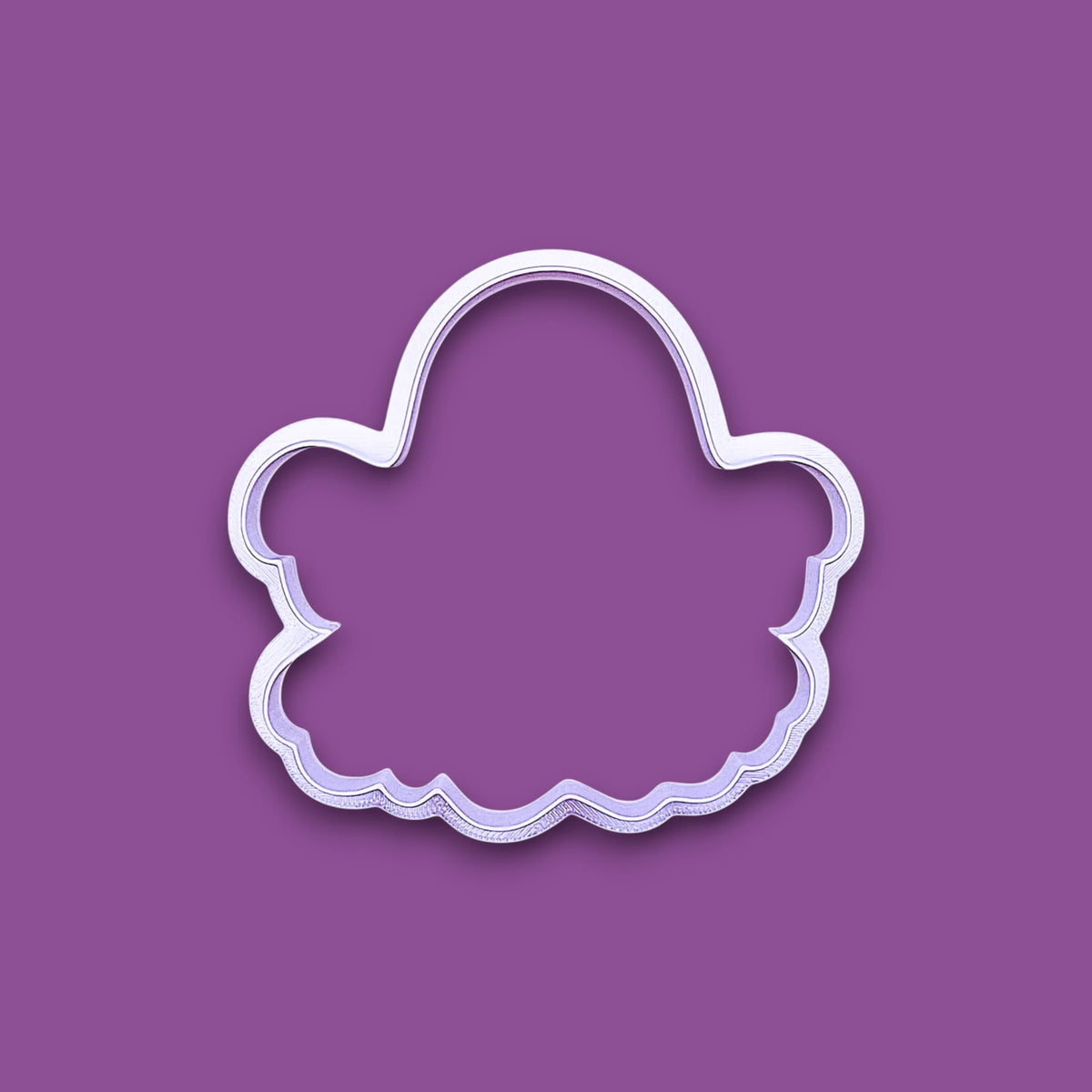 A ghost-shaped cookie cutter, shown on a solid purple background.