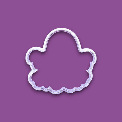 A ghost-shaped cookie cutter, shown on a solid purple background.