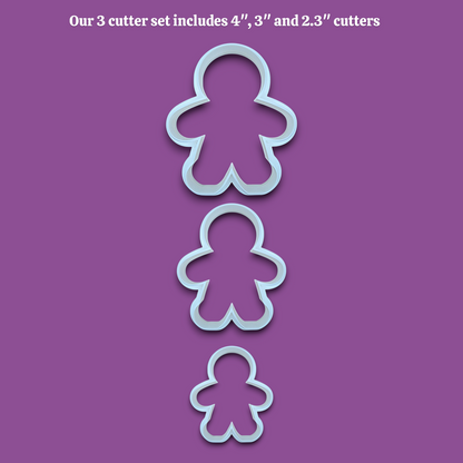 Three gingerbread person-shaped cookie cutters in sizes 4 inches, 3 inches, and 2.3 inches, shown vertically on a solid purple background with white text at the top reading "Our 3 cutter set includes 4", 3", and 2.3" cutters".