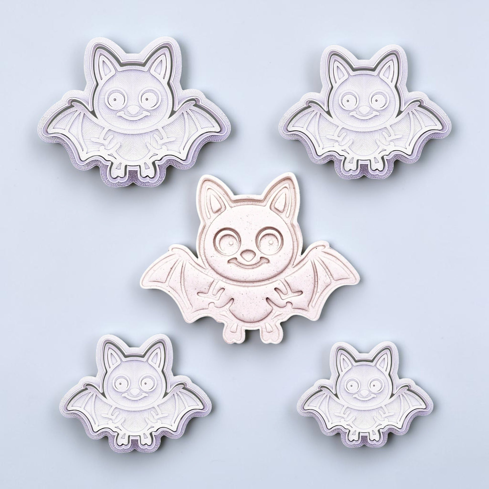 Close-up of bat cookie cutters with matching stamps, perfect for spooky Halloween cookies, fondant crafts, and gothic-themed baking projects.