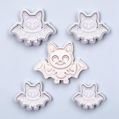 Close-up of bat cookie cutters with matching stamps, perfect for spooky Halloween cookies, fondant crafts, and gothic-themed baking projects.