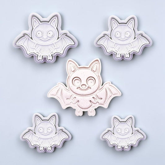 Close-up of bat cookie cutters with matching stamps, perfect for spooky Halloween cookies, fondant crafts, and gothic-themed baking projects.