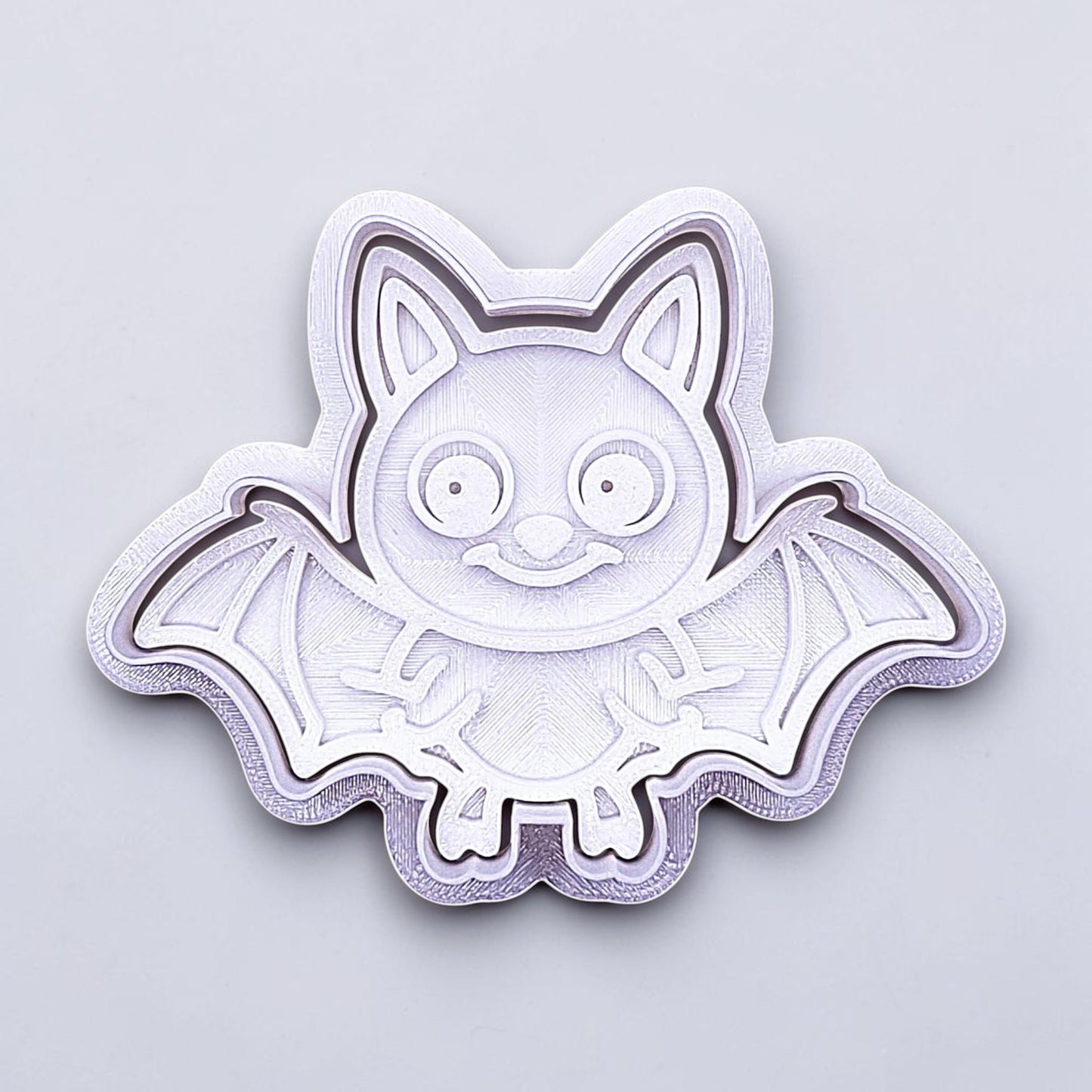 Close-up of bat cookie cutter with matching stamp, perfect for spooky Halloween cookies, fondant crafts, and gothic-themed baking projects.