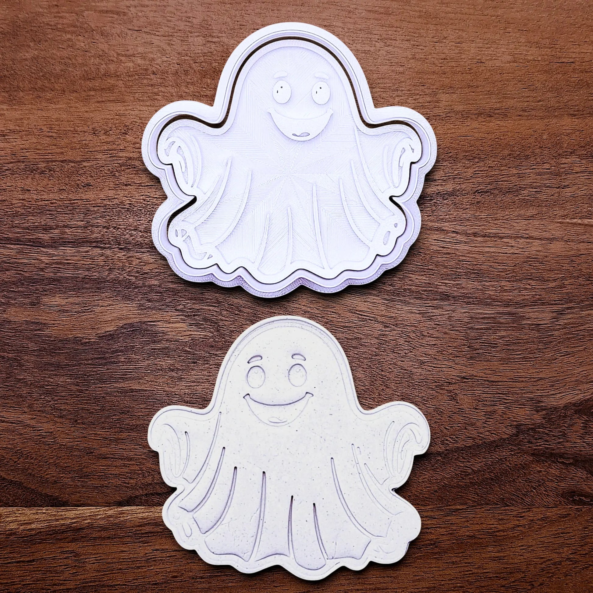 Handmade and customizable ghost cookie cutter and stamp alongside a dough cutout and imprint, great for baking Halloween trick or treats or kid-friendly spooky snacks.