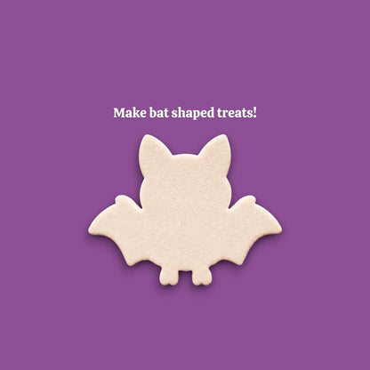 Cookie dough cutouts made with bat cookie cutter. Shows bat and wing shape, ideal for cute Halloween treats.