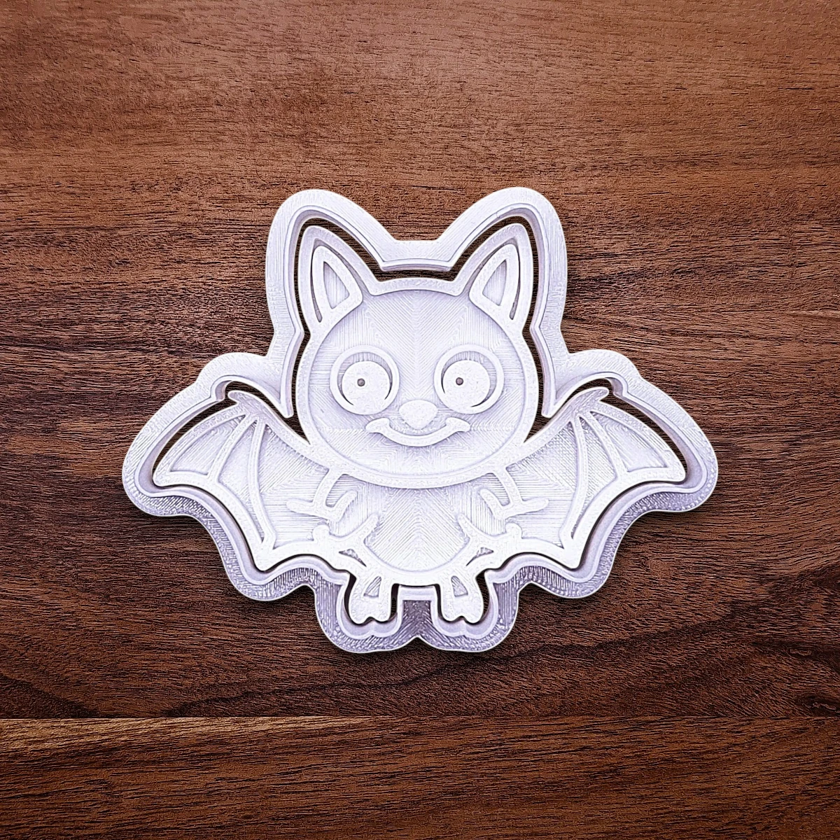Close-up of bat cookie cutter with matching stamp, perfect for spooky Halloween cookies, fondant crafts, and gothic-themed baking projects.