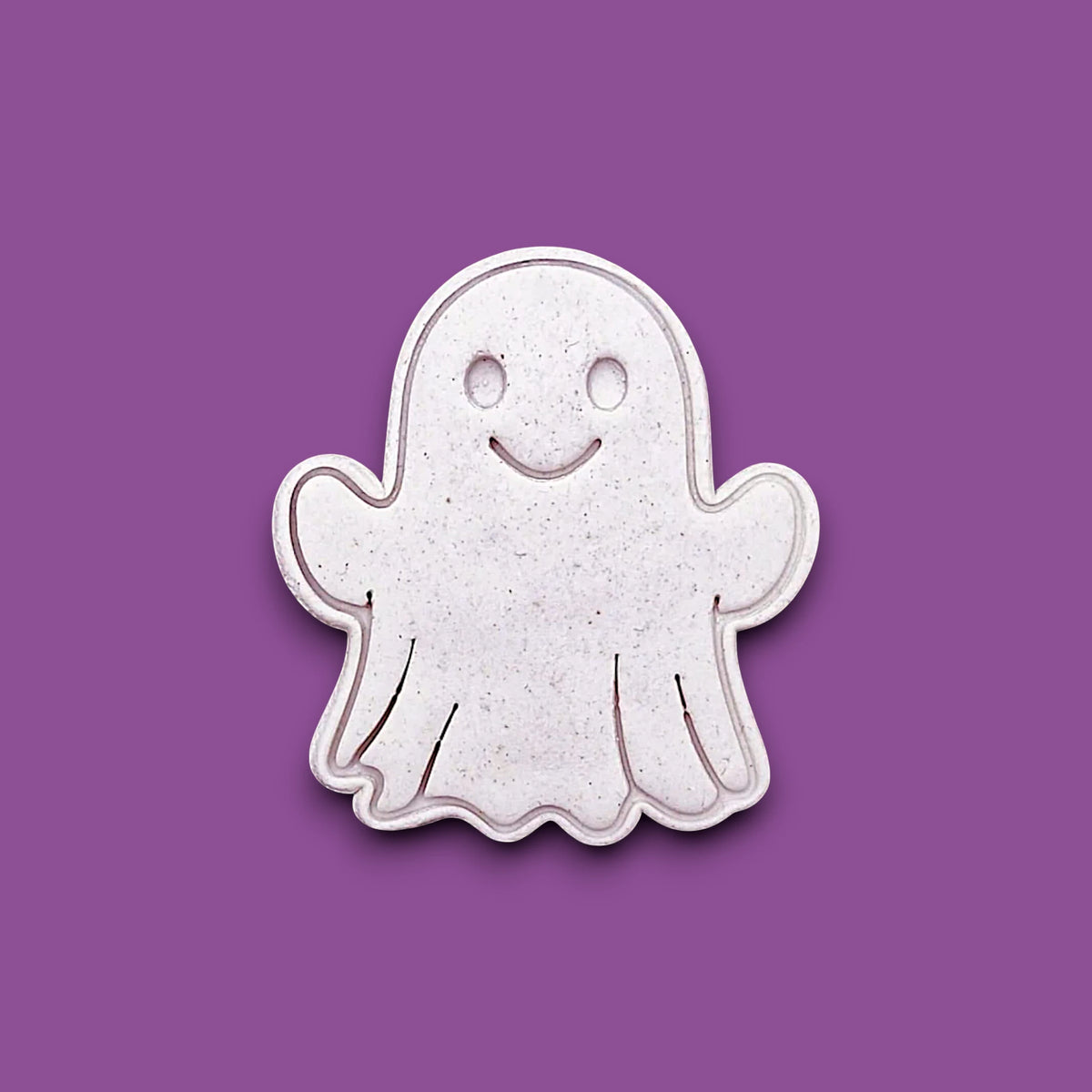 Ghost cookie cutter stamping spooky face into dough – great for Halloween cookies, fondant, or crafts with clean, detailed imprints.