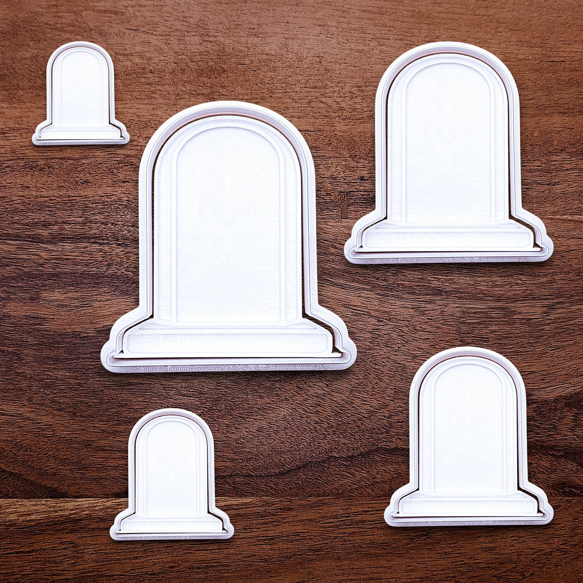 Multiple gravestone cookie cutters with stamps for Halloween treats and spooky desserts, adds detail to dough, fondant, and craft projects.