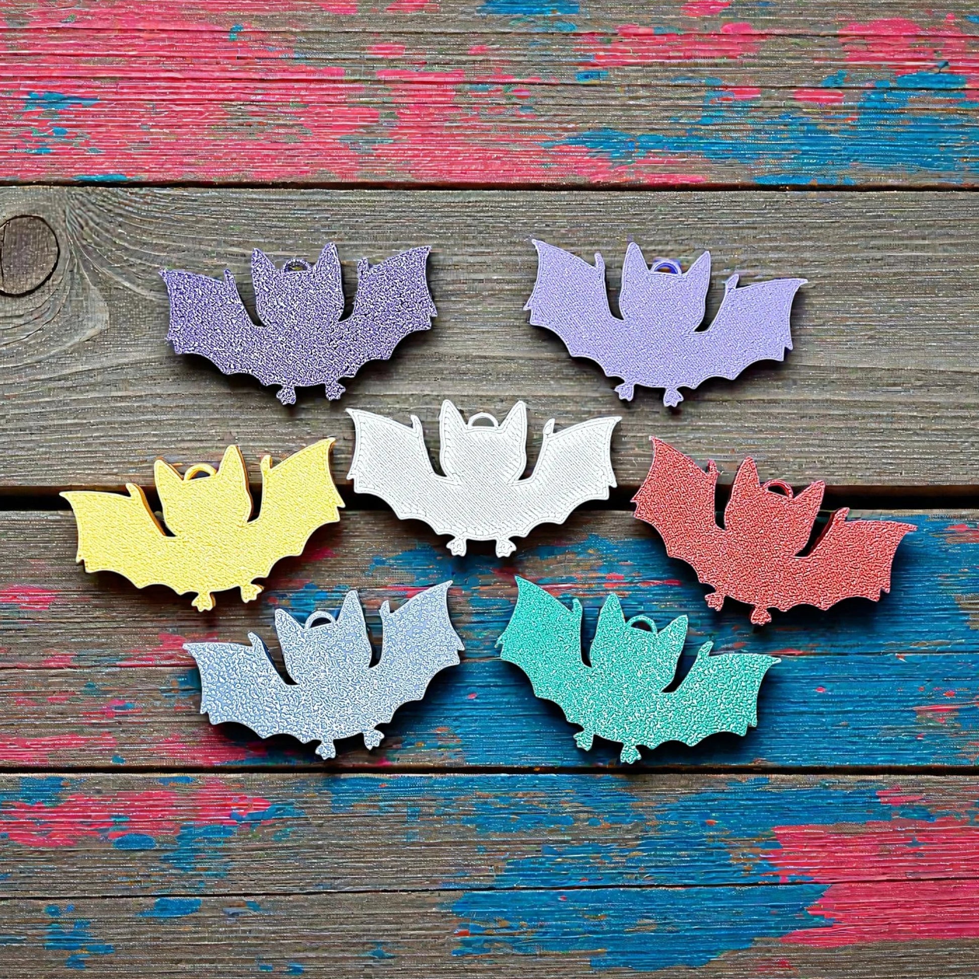 Handmade and customizable bat keychains in assorted colors, perfect for Halloween trick or treats, gothic party favors, and bat-themed accessories.