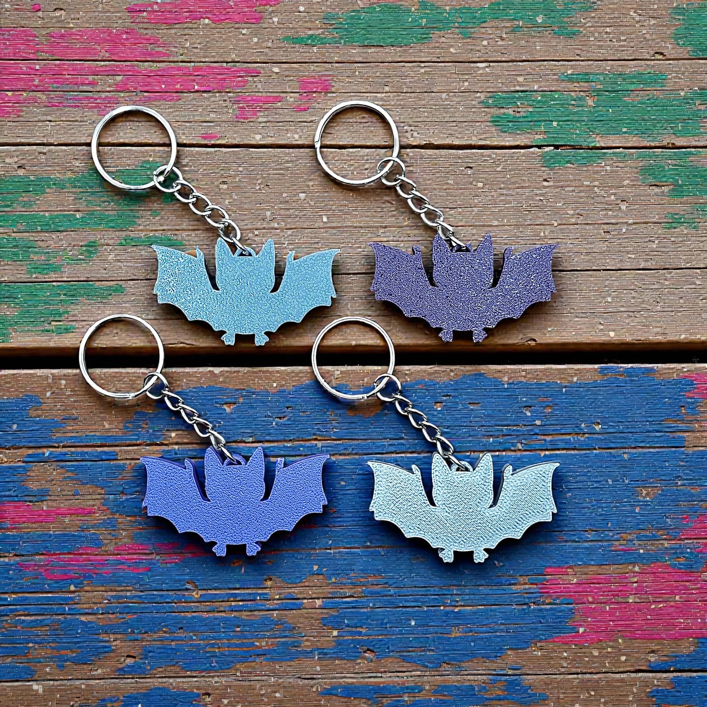 Handmade and customizable bat keychains in various colors, perfect for Halloween trick or treats, gothic party favors, and bat-themed accessories. 