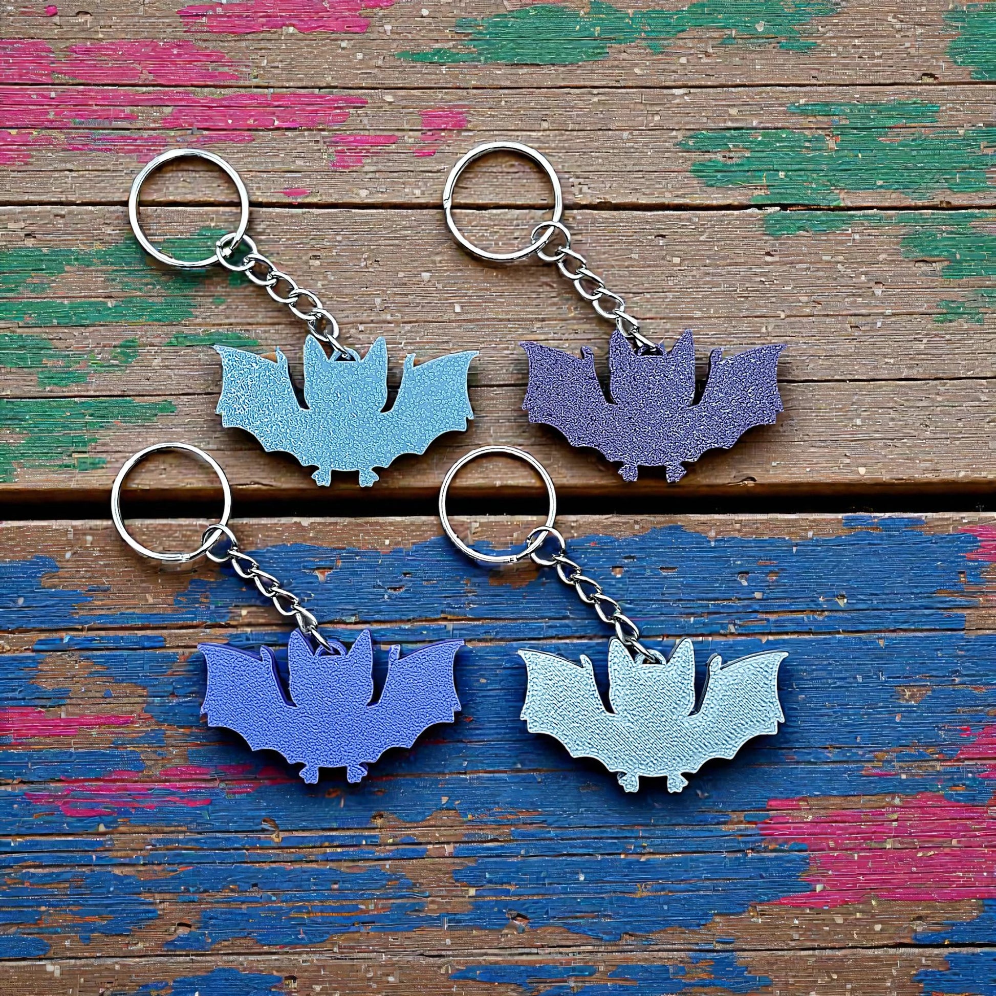 Handmade and customizable bat keychains in various colors, perfect for Halloween trick or treats, gothic party favors, and bat-themed accessories. 