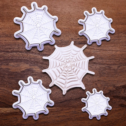 Handmade and customizable Halloween spiderweb cookie cutters and stamps alongside a spiderweb dough cutout and imprint, perfect for fall parties, events, trick or treats, and gifting.