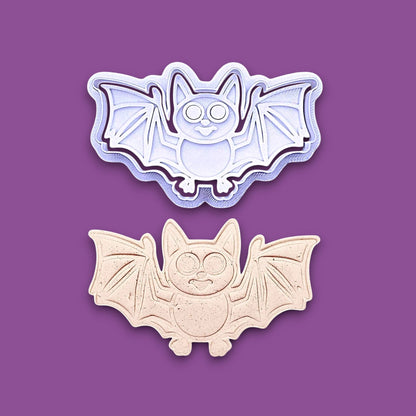 Bat cookie cutter with matching stamps and dough cutout with bat design pressed by cutter and stamp set, showing detailed lines - great for easy Halloween cookie decorating without icing.