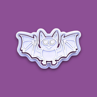 Halloween bat shaped cookie cutter and stamp shown on a purple background.