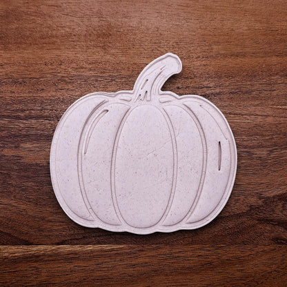 Pumpkin-shaped dough cutouts made with cutter and stamp. Shows detailed lines and clean shapes—ideal for autumn cookies or pie crust toppers.