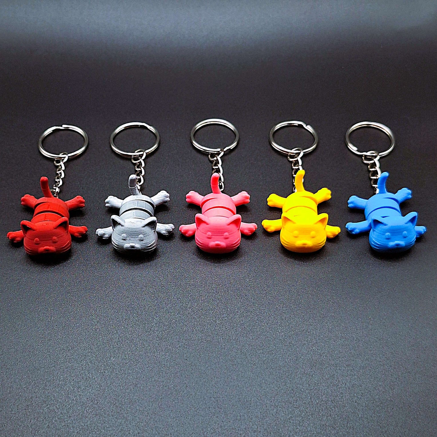 Five eco-friendly articulated cat keychains in front view, great for keys, backpacks, and small gifts with charm.