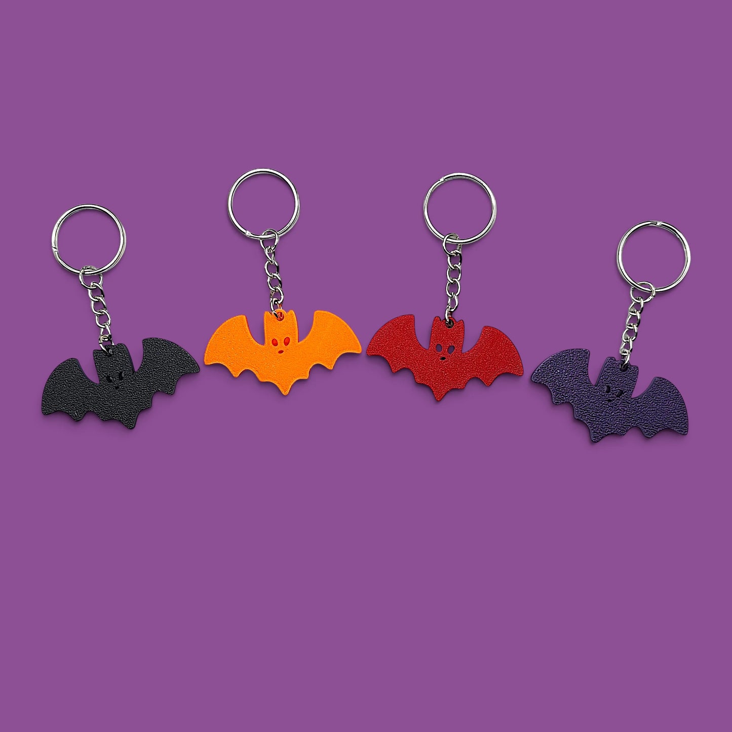 Handmade and customizable bat keychains in various colors, perfect for Halloween gifts, party favors, or gothic-themed keyring collections.