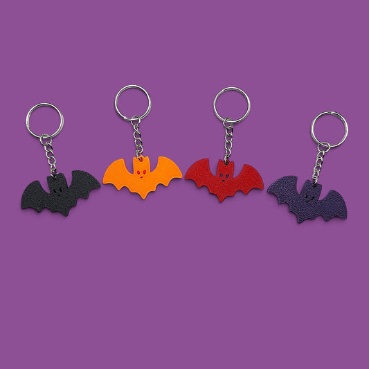 Handmade and customizable bat keychains in various colors, perfect for Halloween gifts, party favors, or gothic-themed keyring collections.