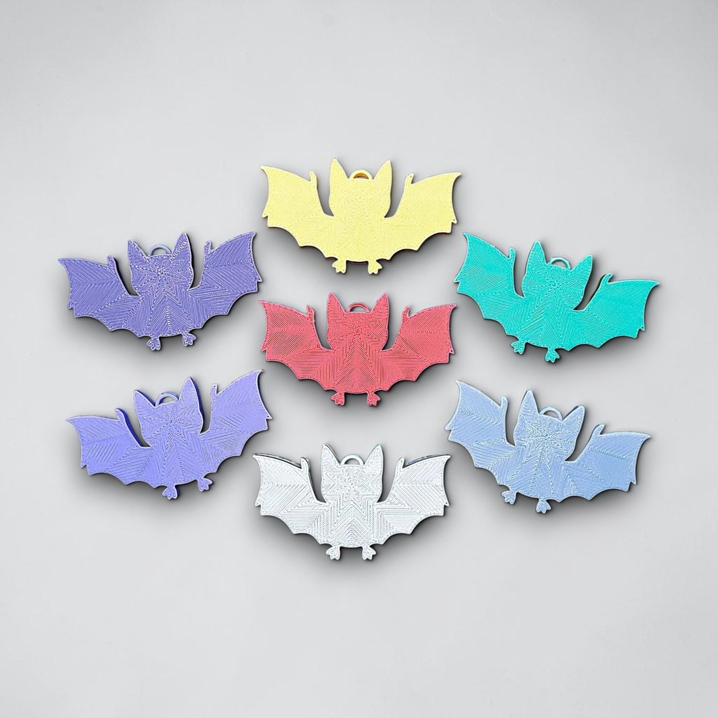 Reverse of handmade and customizable bat keychains, perfect for Halloween trick or treats, gothic party favors, and bat-themed accessories.