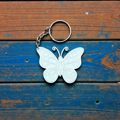 Handmade and customizable butterfly keychain in white, perfect for gifts, party favors, or nature-themed accessories.