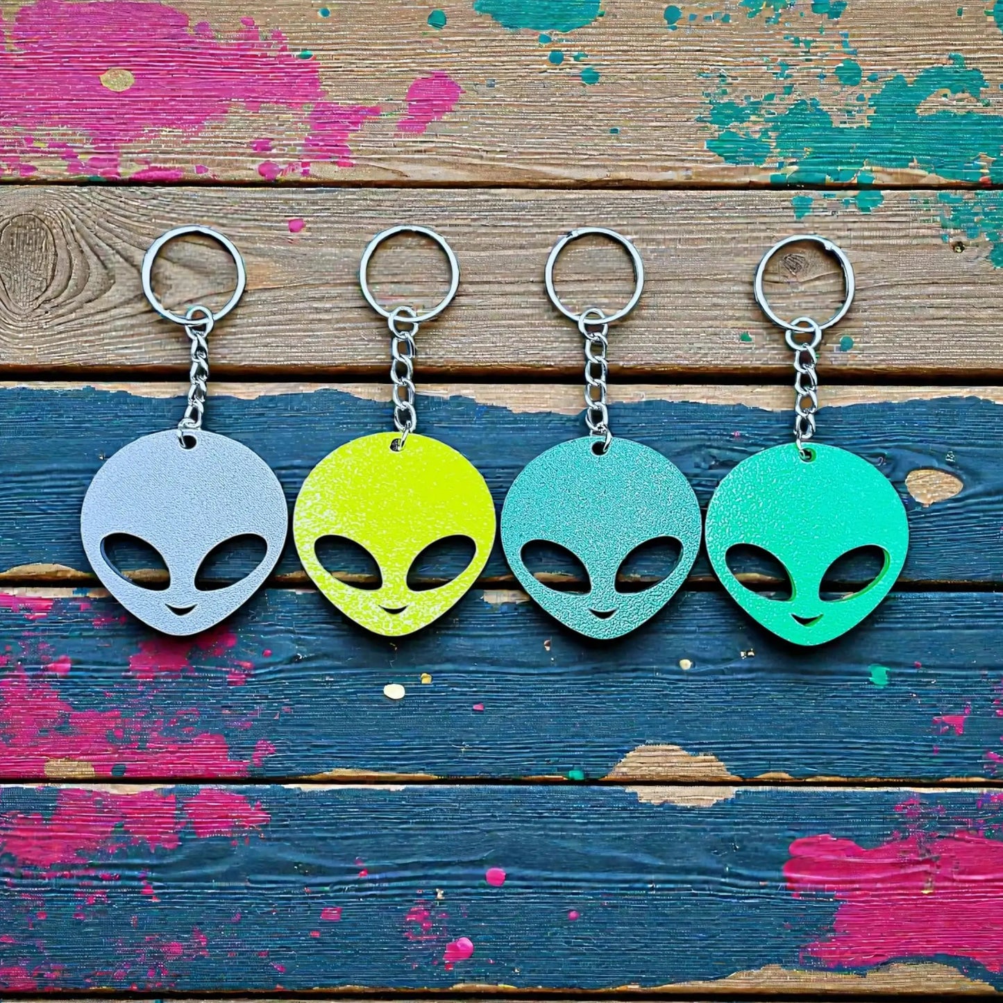 Alien head keychains in four different colors displayed side by side, perfect for sci-fi fans, party favors, or fun personalized gifts.