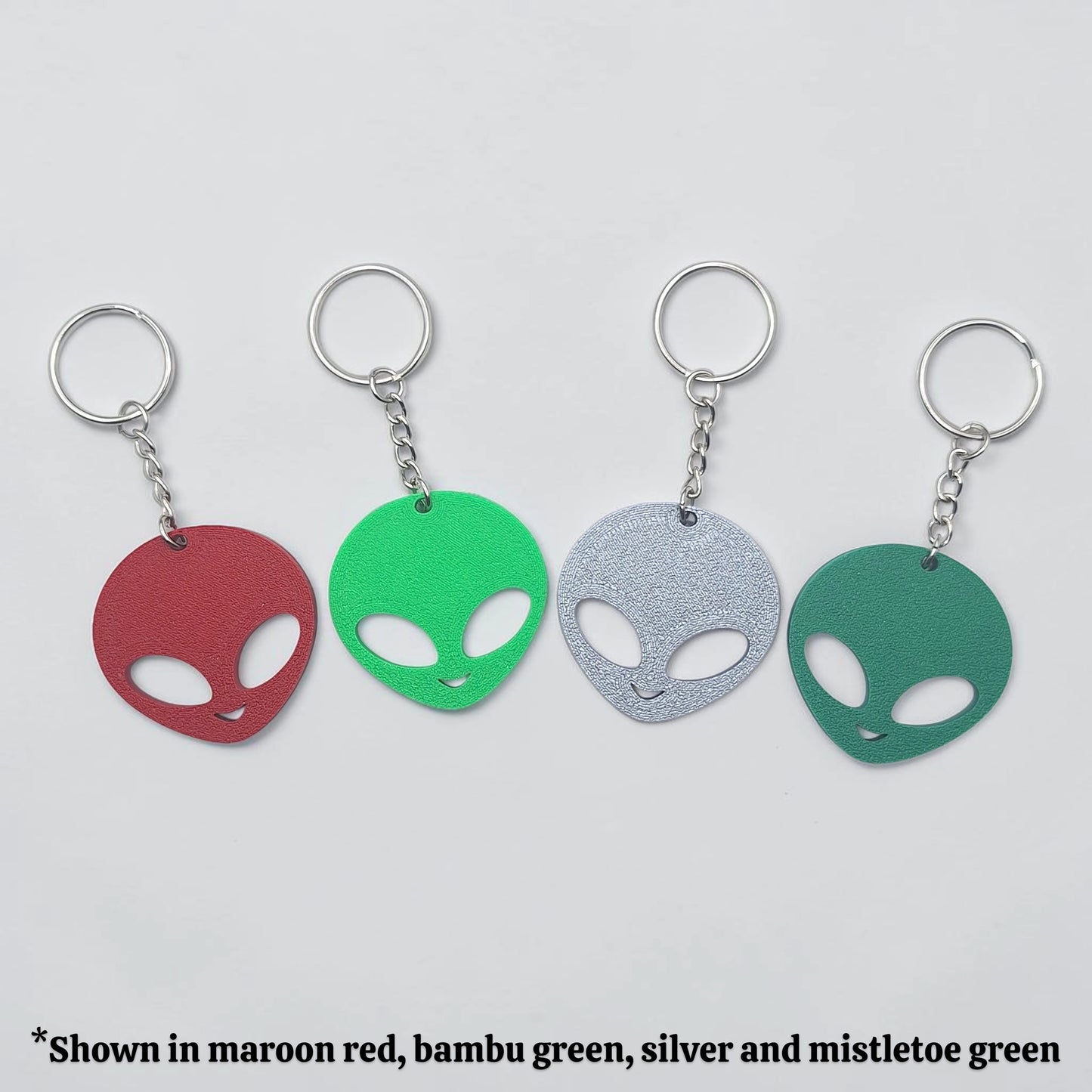 Alien head keychains in different colors displayed side by side, perfect for sci-fi fans, party favors, or fun personalized gifts.