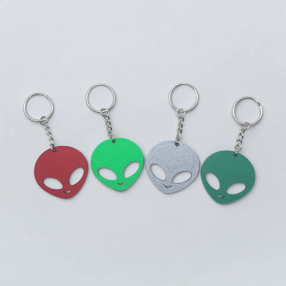Alien head keychains in four different colors displayed side by side, perfect for sci-fi fans, party favors, or fun personalized gifts.