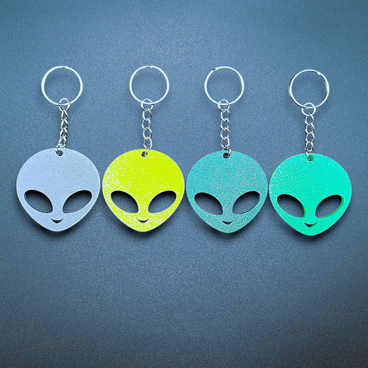 Alien head keychains in four different colors displayed side by side, perfect for sci-fi fans, party favors, or fun personalized gifts.