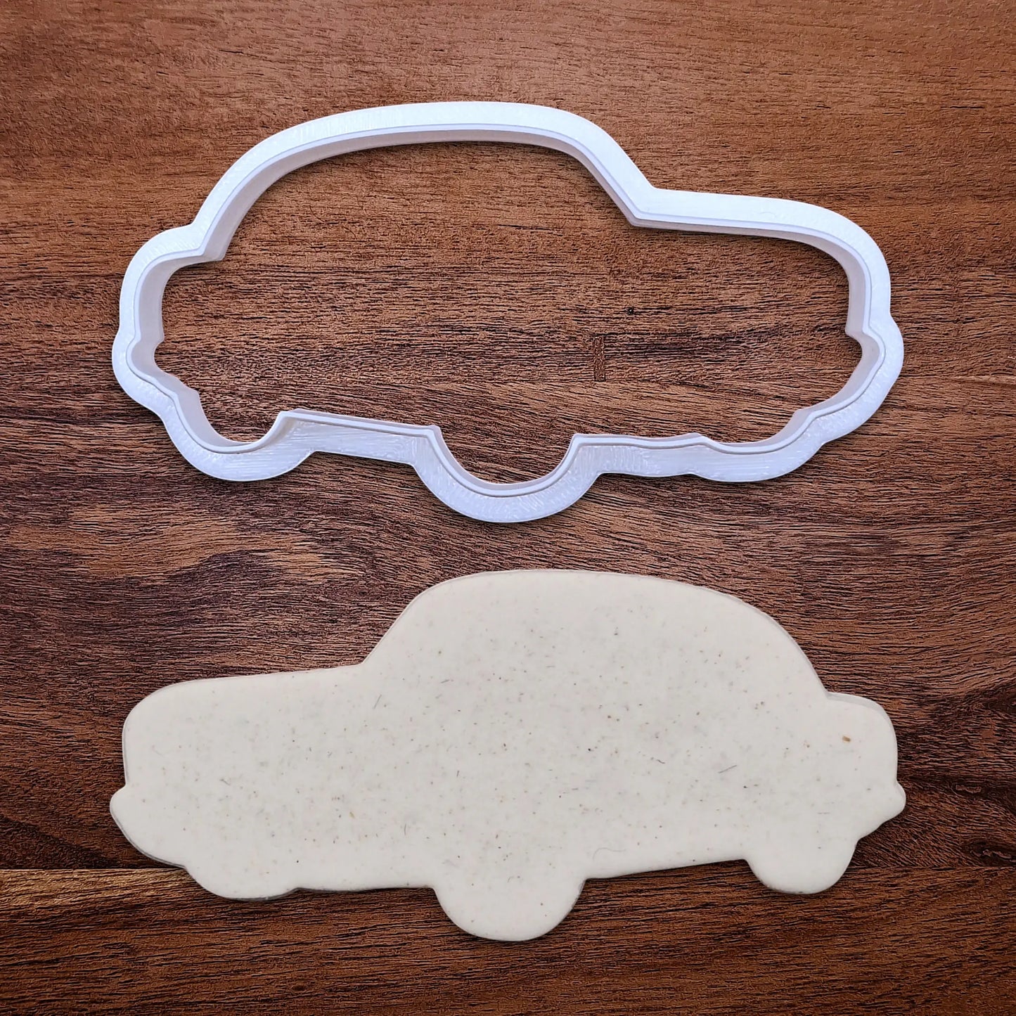 Handmade and customizable antique roadster car cookie cutter alongside a dough cutout, perfect for vintage car themed cookies, birthdays and gifting.