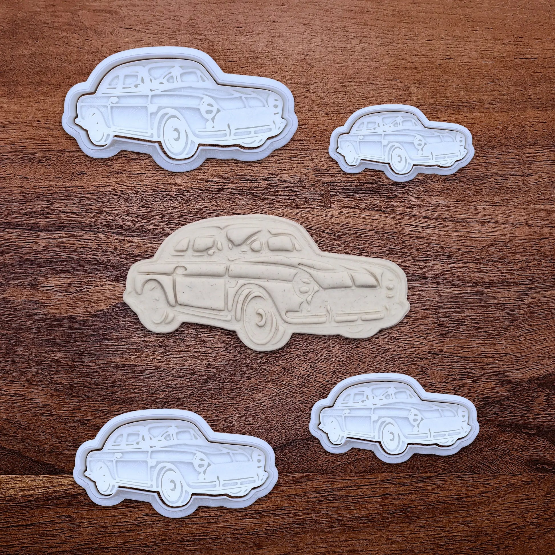 Handmade and customizable antique roadster car cookie cutters and stamps alongside a dough cutout and imprint, perfect for vintage car themed cookies, birthdays and gifting.