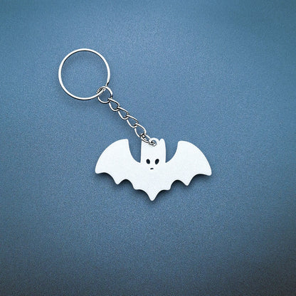 White bat keychain—bold, creepy-cute charm handmade from plant-based plastic; great for vampire fans, goth gifts, or Halloween keyrings.