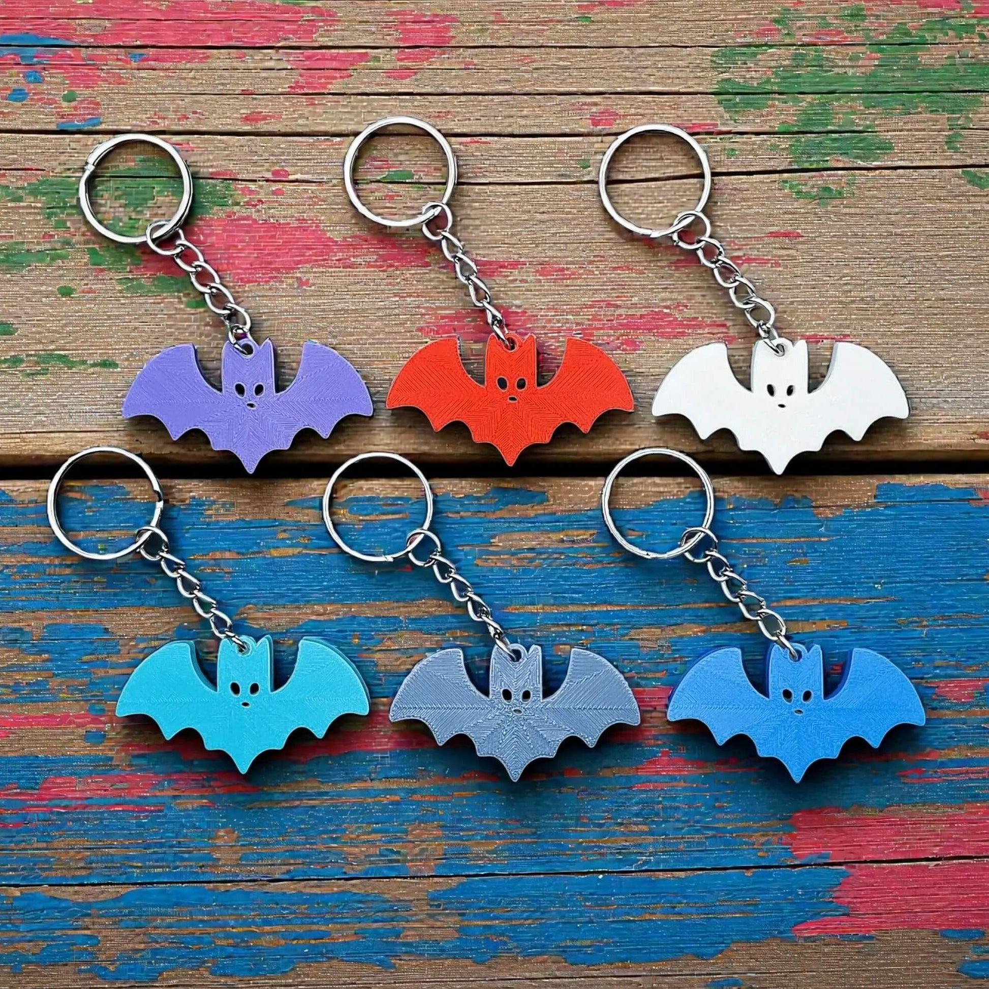 Handmade and customizable bat keychains in various colors, perfect for Halloween gifts, party favors, or gothic-themed keyring collections.