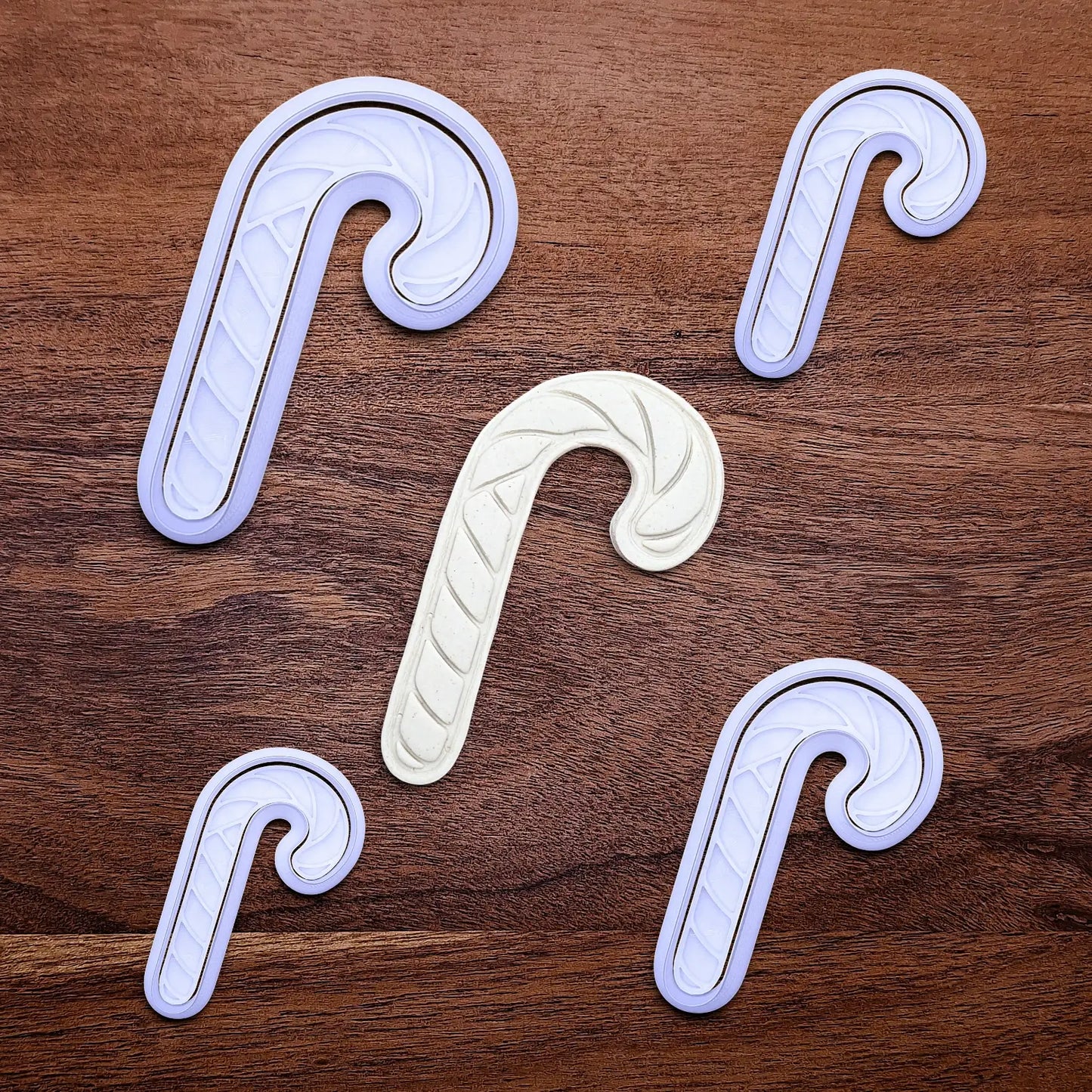 Handmade and customizable Christmas holiday Candy Cane Cookie Cutters and Stamps alongside a dough cutout and imprint - stamp adds stripe details for Christmas cookies, festive gifts, and fun seasonal family baking activities.