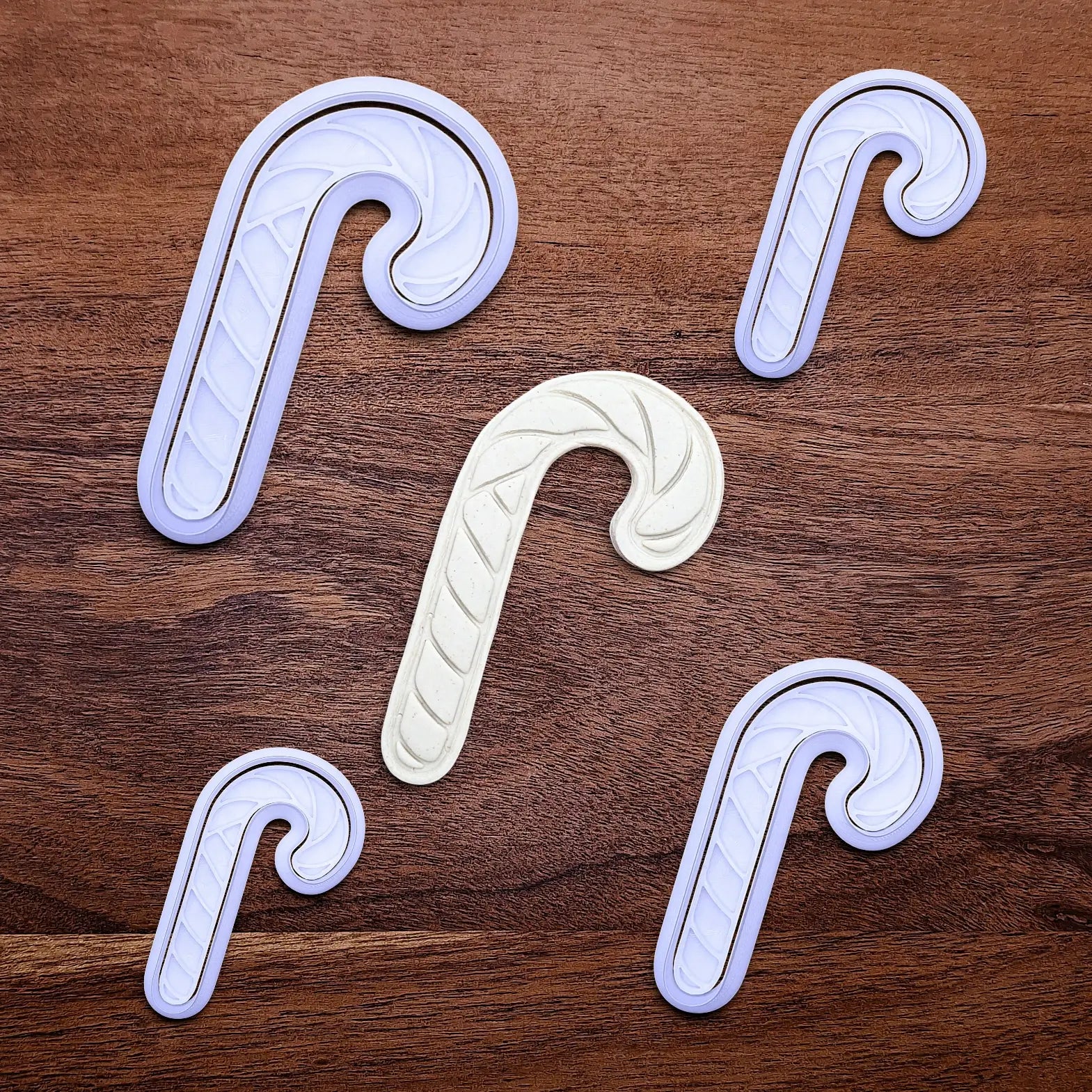 Handmade and customizable Christmas holiday Candy Cane Cookie Cutters and Stamps alongside a dough cutout and imprint - stamp adds stripe details for Christmas cookies, festive gifts, and fun seasonal family baking activities.