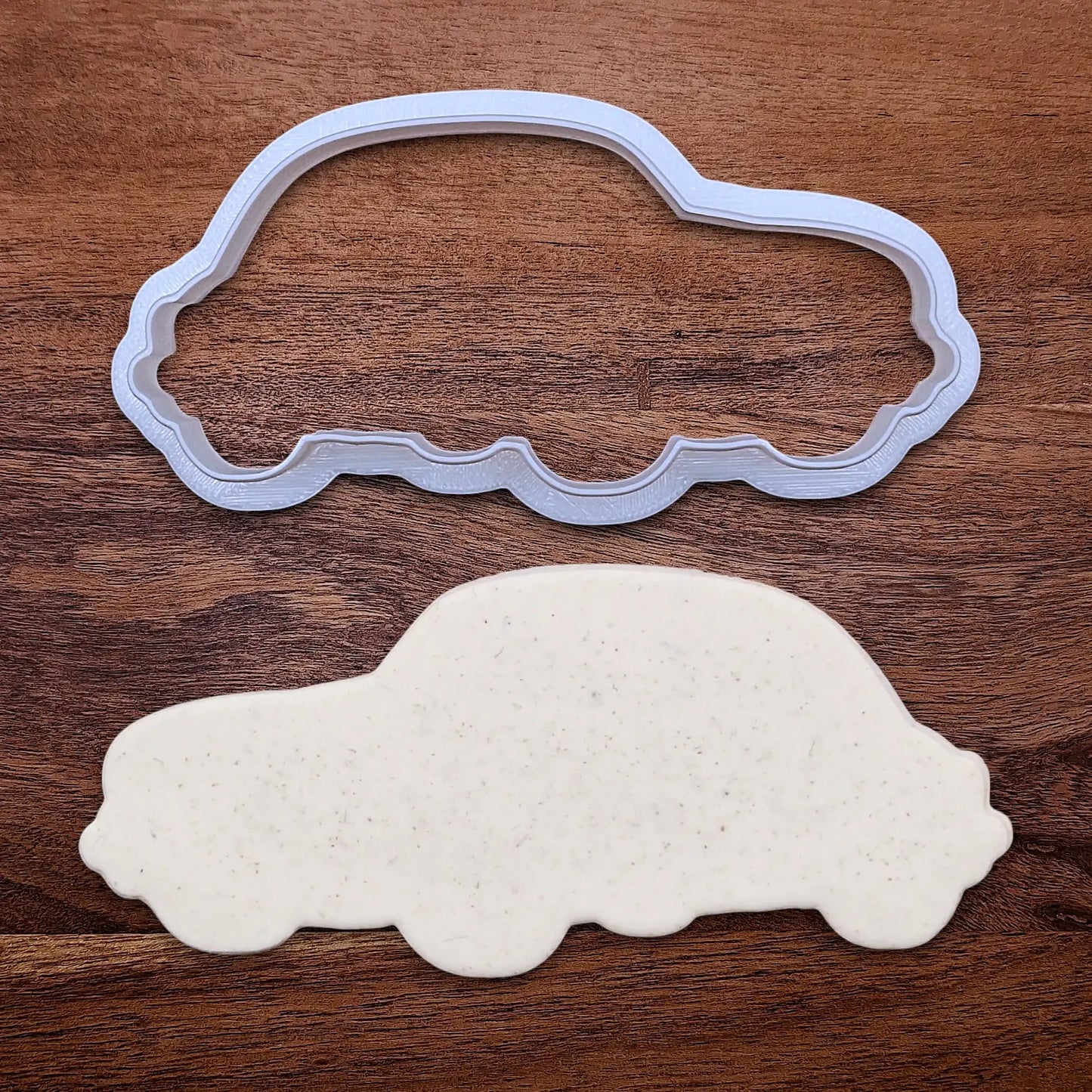 Handmade and customizable punch buggy car cookie cutter alongside a dough cutout, perfect for vintage car themed cookies, birthdays and gifting.