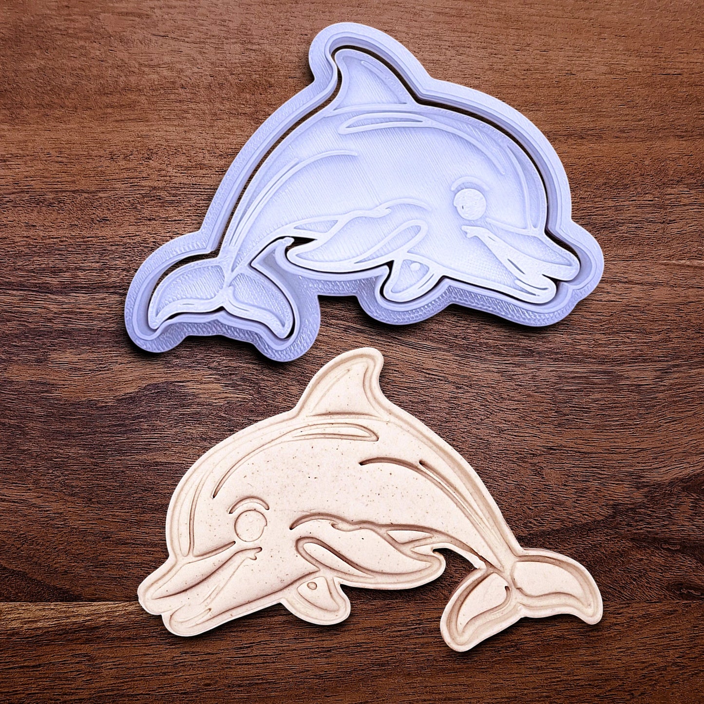Handmade and customizable dolphin cookie cutter and stamp alongside a dough imprint, perfect for ocean-themed cookies, birthdays, aquatic fondant toppers, and sea animal baking projects.