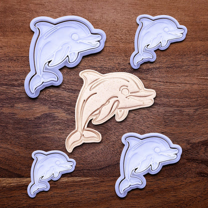 Handmade and customizable dolphin cookie cutter stamp set in multiple sizes alongside a dough imprint, perfect for ocean-themed cookies, birthdays, aquatic fondant toppers, and sea animal baking projects.