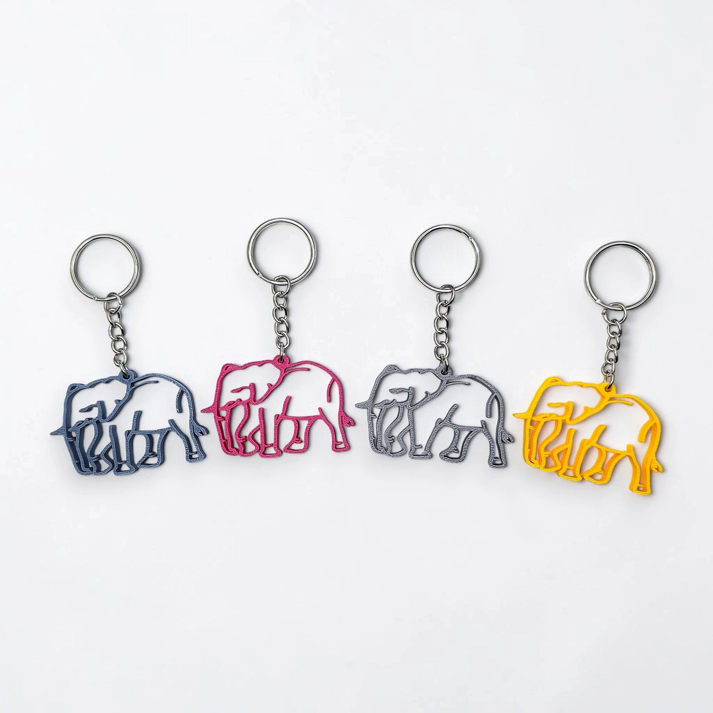 Four elephant-shaped keychains in different colors on a white background