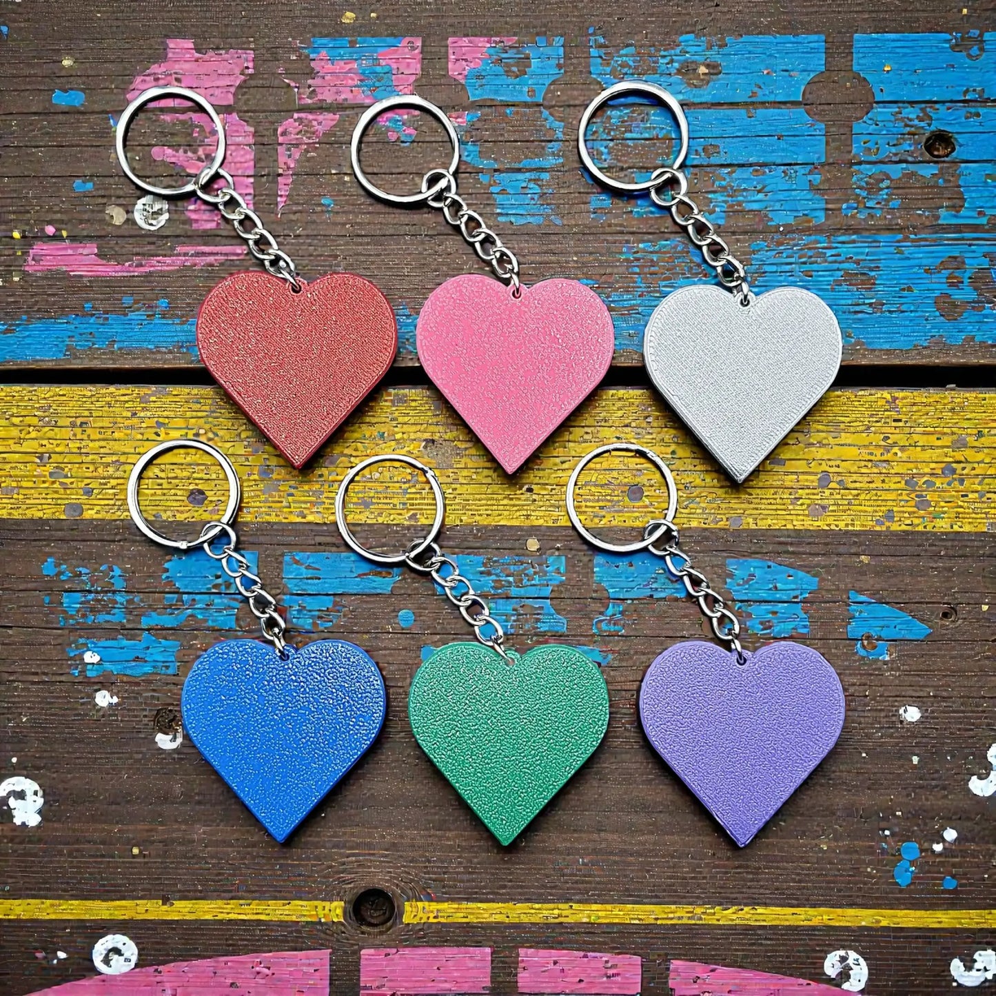 Handmade and customizable heart keychains in assorted colors, perfect for classroom prizes, Valentine's Day gifts, party favors for kids birthdays, baby showers and unique backpack charms.