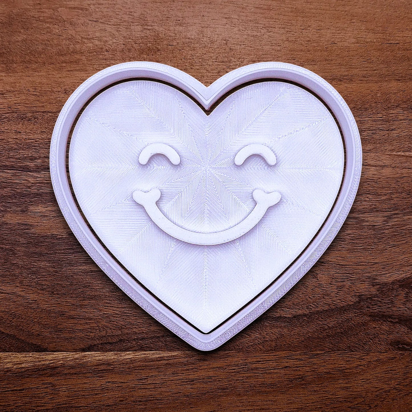 Handmade and customizable heart cookie cutter with cute face stamp, perfect for Valentine's Day baking, sweet treats and party favor creations.